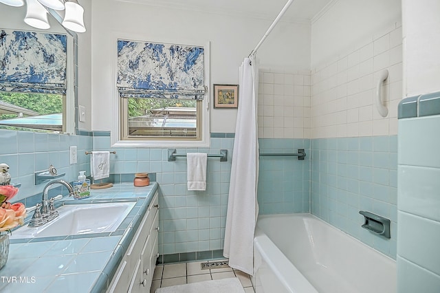 full bathroom with ornamental molding, tile patterned flooring, shower / bath combination with curtain, vanity, and tile walls