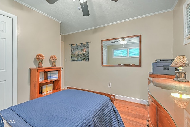 bedroom with ornamental molding, light wood-style flooring, baseboards, and a ceiling fan