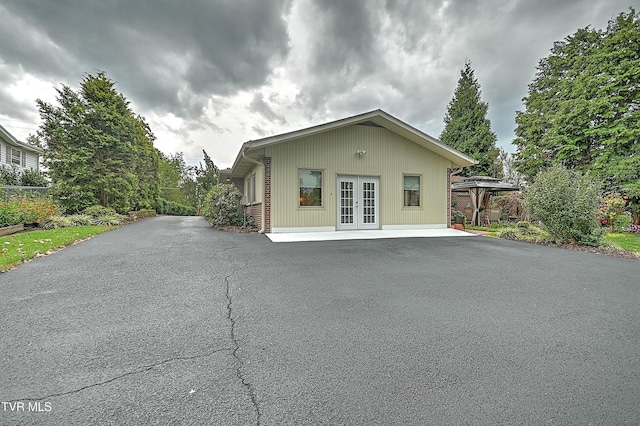 view of side of home with a gazebo, french doors, and driveway