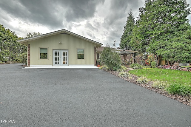 rear view of property featuring french doors and a lawn