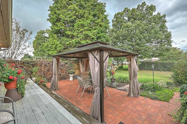 wooden terrace with a patio area, outdoor dining area, a fenced backyard, and a gazebo