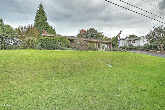 view of front of house with a chimney and a front lawn