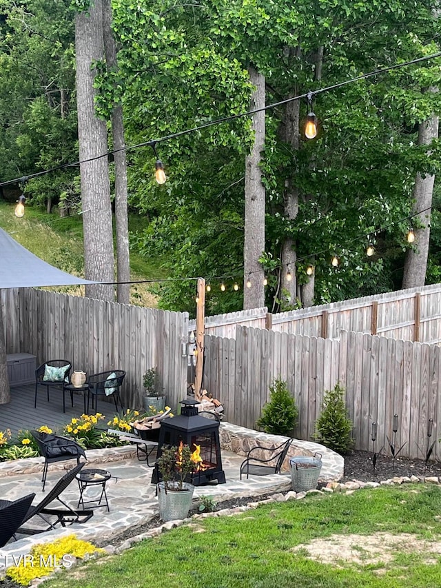 view of yard with fence, a fire pit, and a patio