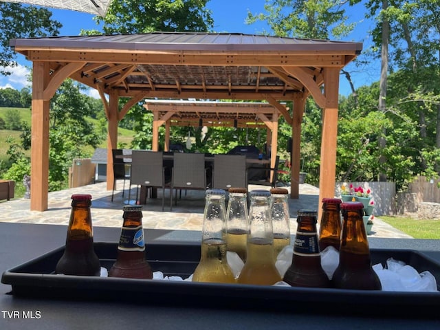 exterior space featuring a gazebo, outdoor dining area, a patio, and fence