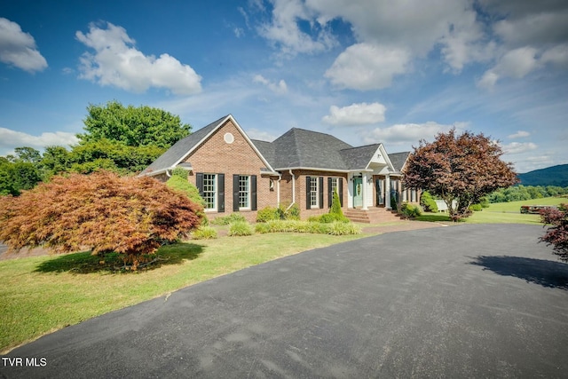 view of front of house featuring a front lawn and brick siding