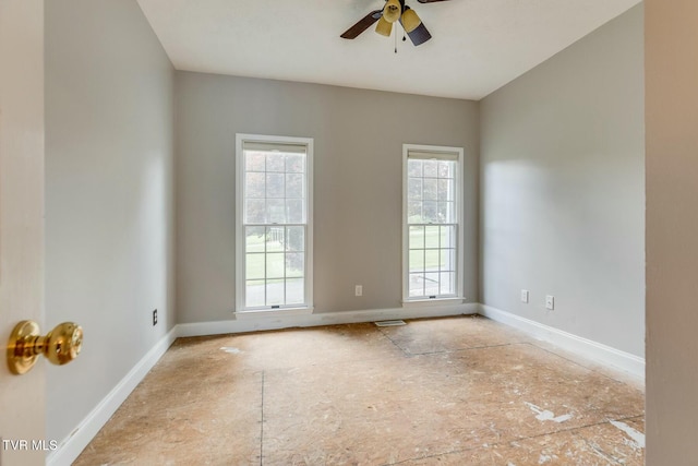 spare room featuring ceiling fan, visible vents, and baseboards