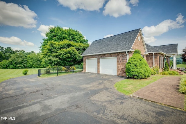 view of side of property featuring an attached garage, brick siding, a shingled roof, fence, and driveway