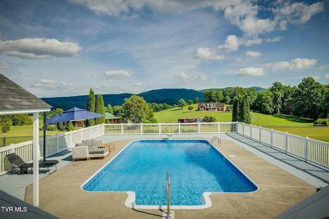 view of swimming pool featuring fence, a mountain view, a fenced in pool, and a patio