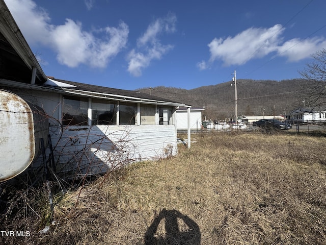 view of side of home featuring fence and a mountain view