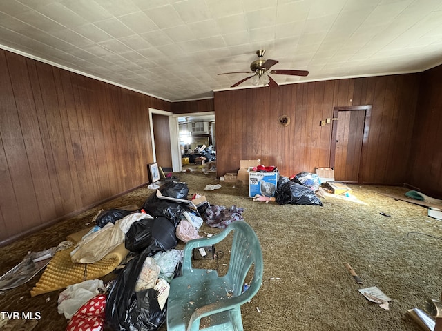 unfurnished living room featuring a ceiling fan and wooden walls