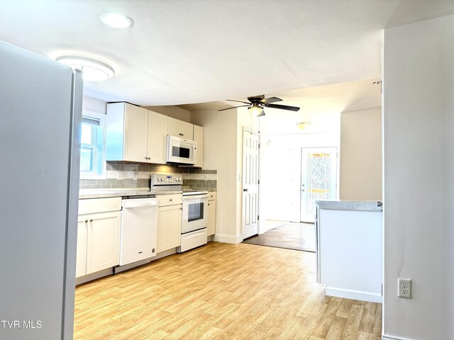 kitchen featuring white appliances, white cabinetry, light wood-style floors, light countertops, and tasteful backsplash