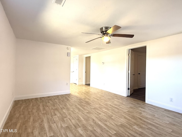 empty room featuring visible vents, baseboards, and wood finished floors