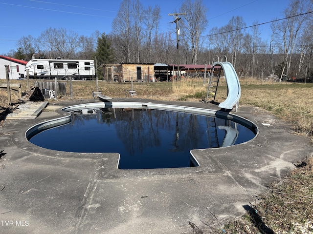 pool featuring a diving board and a water slide