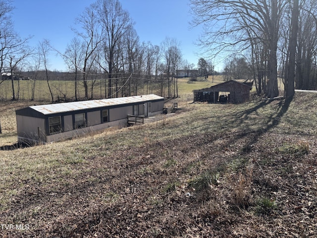 view of yard featuring an outbuilding, a rural view, and an outdoor structure