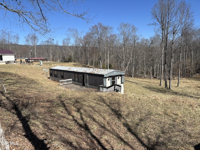 exterior space with an outdoor structure, a view of trees, and metal roof