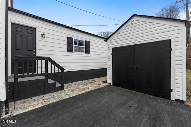 property entrance with a patio area and a detached garage