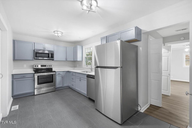 kitchen with baseboards, visible vents, stainless steel appliances, light countertops, and a sink