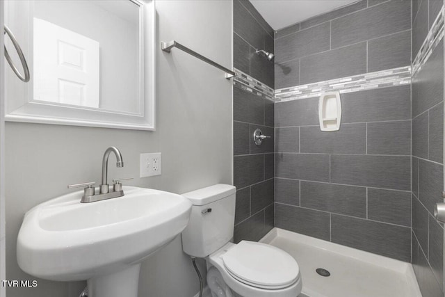 full bathroom featuring toilet, a shower stall, and a sink