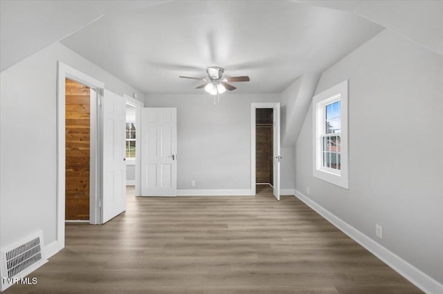 interior space featuring baseboards, visible vents, ceiling fan, and wood finished floors