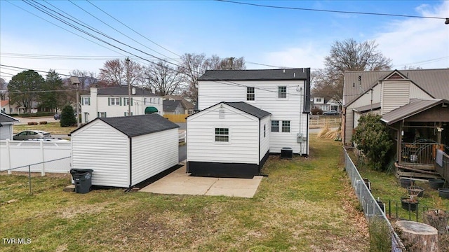 back of house featuring an outbuilding, a fenced backyard, cooling unit, a storage shed, and a yard