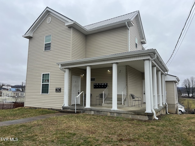 view of front of house with metal roof, a front lawn, and a porch