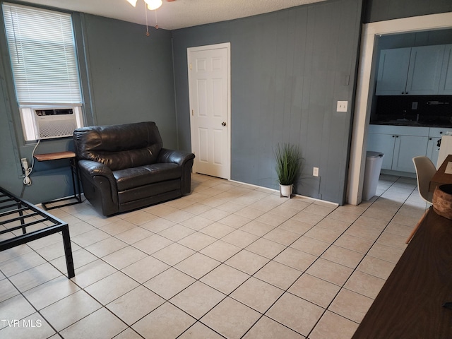 living area with light tile patterned floors, ceiling fan, and cooling unit