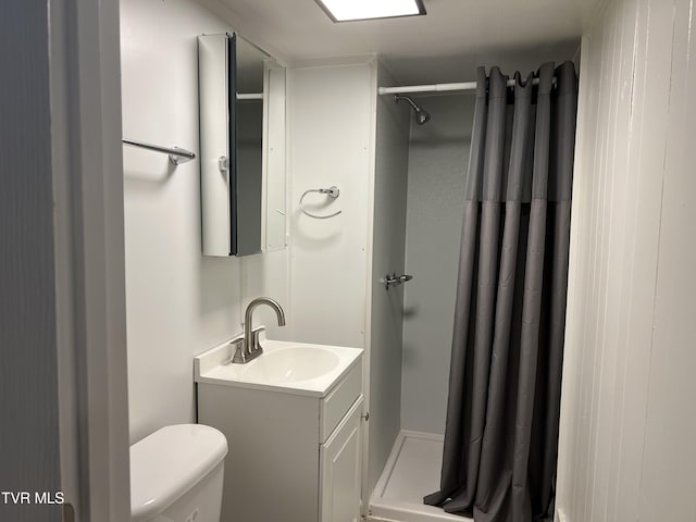 full bath with vanity, a shower stall, and toilet