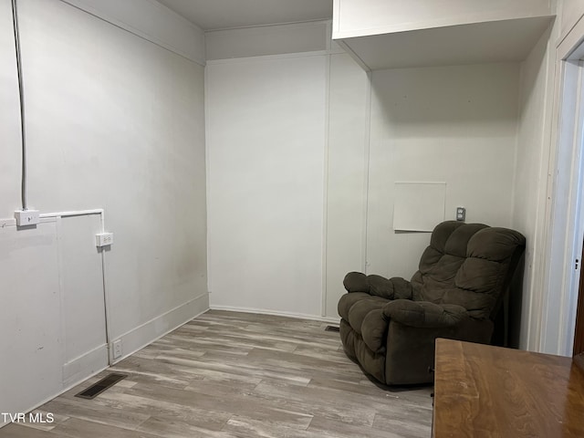 living area with light wood-style flooring and visible vents