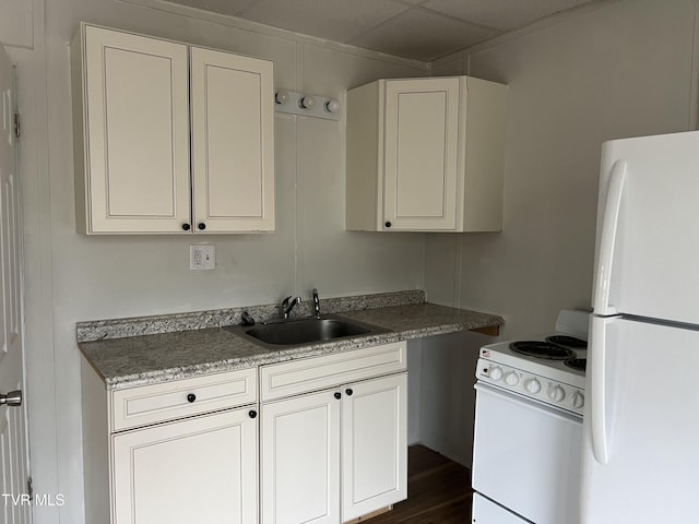 kitchen featuring white appliances, white cabinetry, a sink, and dark wood-style flooring