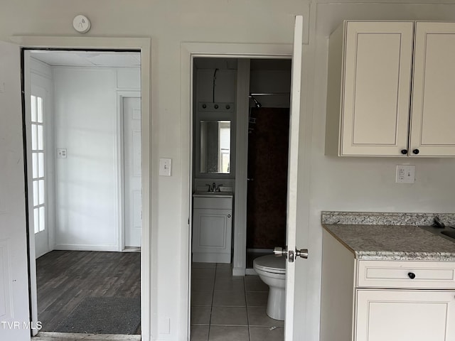 full bath featuring toilet, baseboards, vanity, and tile patterned floors