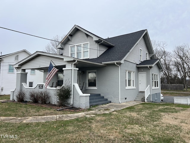 bungalow-style house with entry steps, brick siding, crawl space, roof with shingles, and a front yard