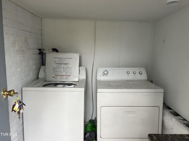 laundry room featuring concrete block wall, laundry area, and washer and dryer