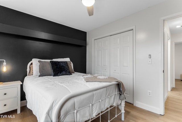 bedroom with light wood-style floors, a closet, ceiling fan, and baseboards