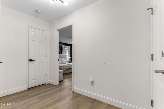 bedroom featuring light wood finished floors and baseboards