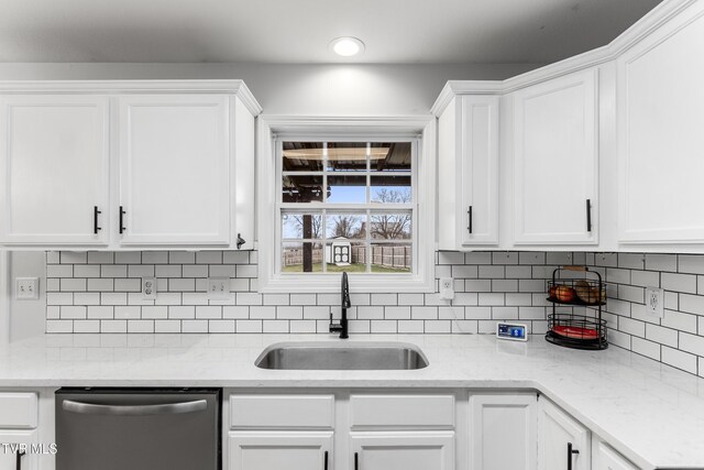 kitchen with a sink, white cabinets, and dishwasher