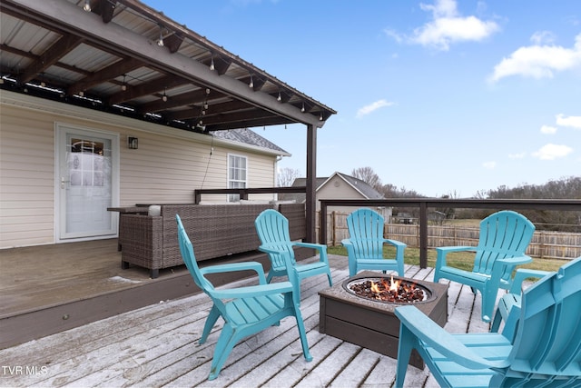 wooden deck with an outdoor fire pit and fence