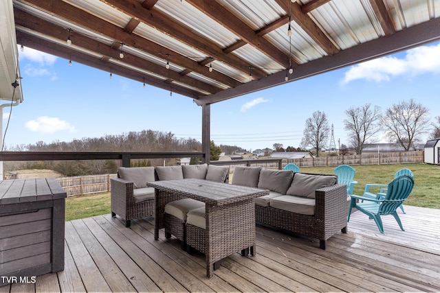 wooden terrace featuring an outbuilding, a fenced backyard, outdoor lounge area, a yard, and a storage unit