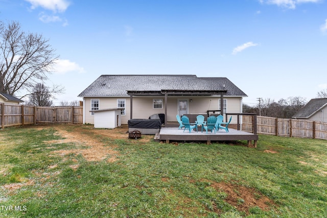 back of house with a fenced backyard, a yard, and a wooden deck