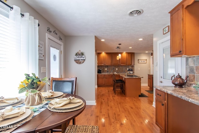dining room with recessed lighting, visible vents, a textured ceiling, light wood-type flooring, and baseboards