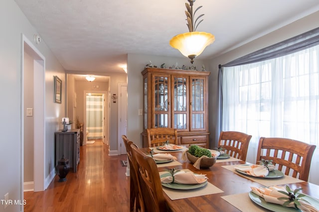 dining space featuring light wood-style floors and baseboards
