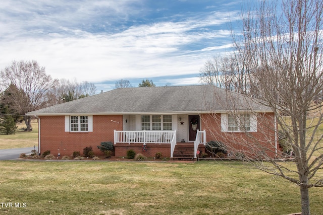 ranch-style house with a shingled roof, a front yard, a porch, and brick siding