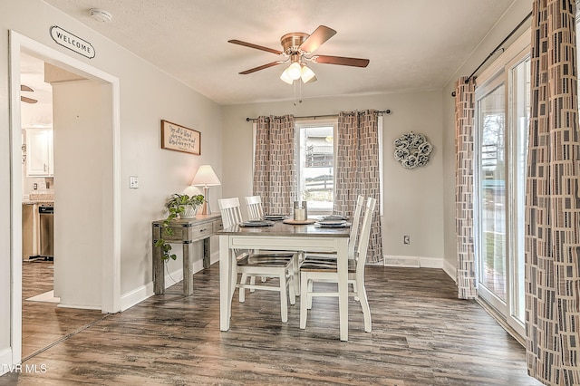 dining room with ceiling fan, a textured ceiling, dark wood finished floors, and baseboards