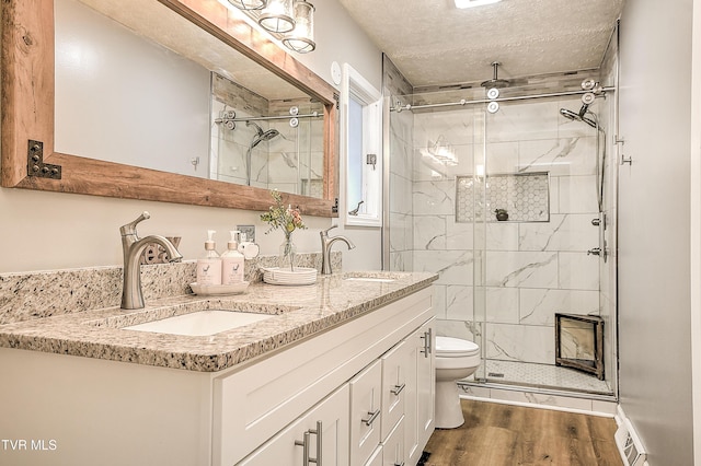 full bath featuring wood finished floors, a sink, and a shower stall