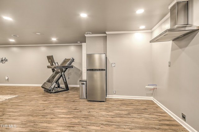 workout area featuring baseboards, ornamental molding, wood finished floors, and recessed lighting