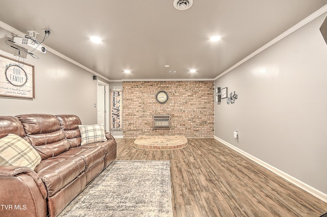 living area featuring ornamental molding, a brick fireplace, wood finished floors, and visible vents