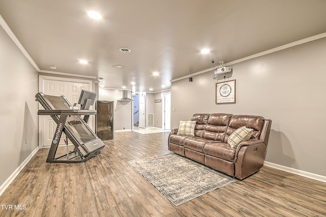 living area with crown molding, baseboards, and wood finished floors