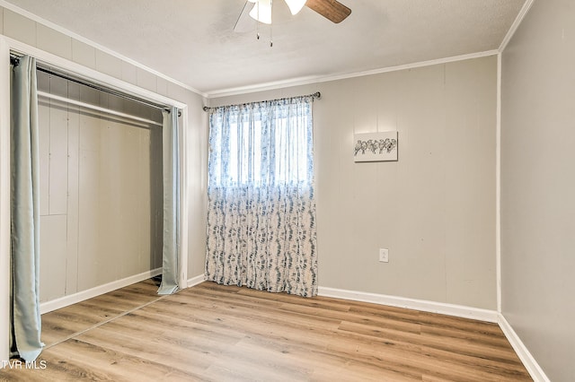 unfurnished bedroom featuring a textured ceiling, ceiling fan, wood finished floors, a closet, and crown molding