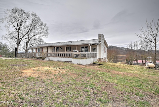 view of front of property with metal roof, a chimney, a front yard, and fence