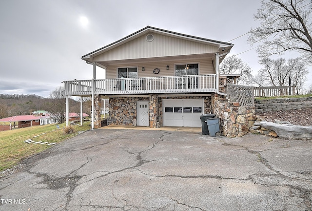 view of front of home with stone siding, aphalt driveway, and an attached garage