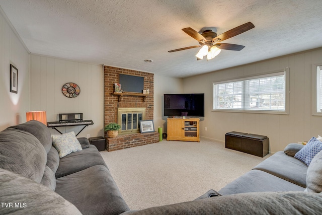 carpeted living area featuring a textured ceiling, a brick fireplace, and a ceiling fan